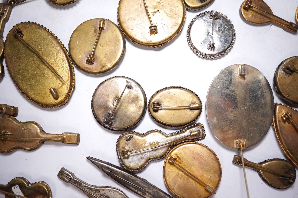 A collection of twenty-eight brooches, including fourteen mixed guitar and banjo shaped brooches, six large oval brooches, seven smaller brooches and one small oval., Condition - good
